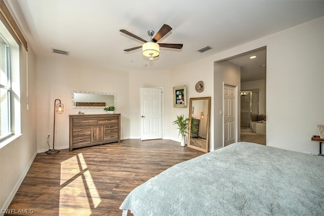 bedroom with ceiling fan, ensuite bathroom, and dark wood-type flooring