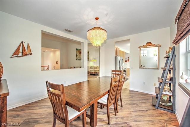 dining area with an inviting chandelier and light hardwood / wood-style floors