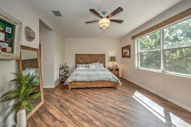 bedroom with dark hardwood / wood-style floors and ceiling fan