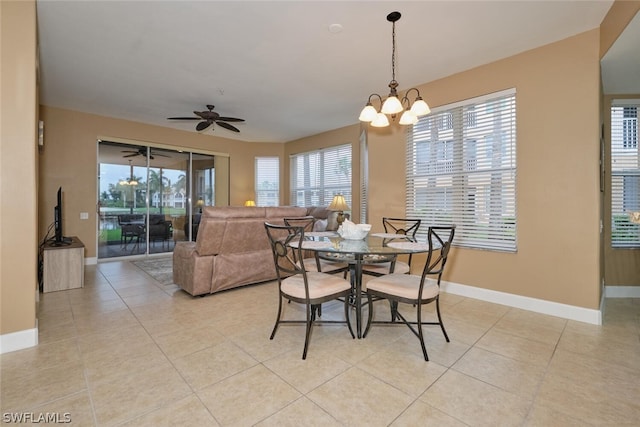 tiled dining room with ceiling fan with notable chandelier