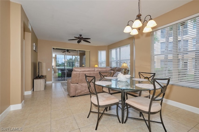 tiled dining room featuring ceiling fan with notable chandelier