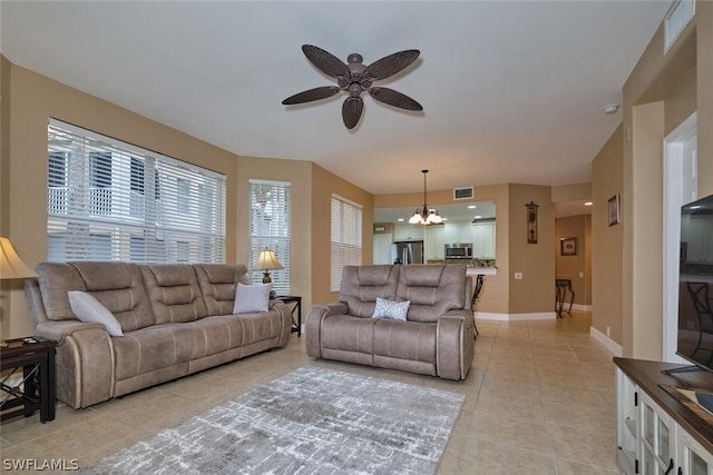 living room with ceiling fan with notable chandelier and light tile patterned flooring