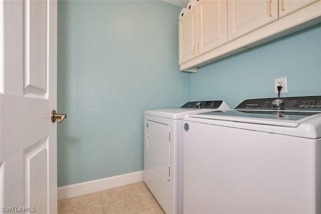 washroom featuring light tile patterned floors, separate washer and dryer, and cabinets