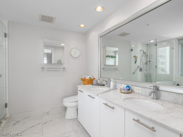 bathroom with vanity, toilet, and a shower with door