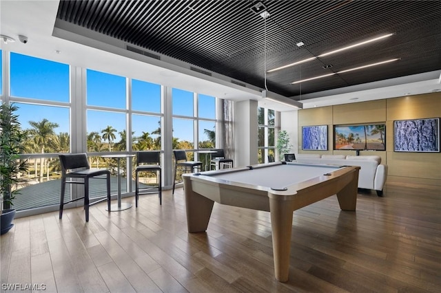 game room with a wall of windows, hardwood / wood-style flooring, plenty of natural light, and pool table