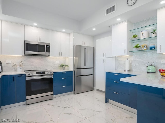 kitchen featuring blue cabinetry, white cabinetry, stainless steel appliances, and backsplash