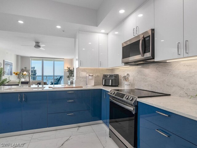 kitchen with appliances with stainless steel finishes, sink, blue cabinets, and white cabinetry