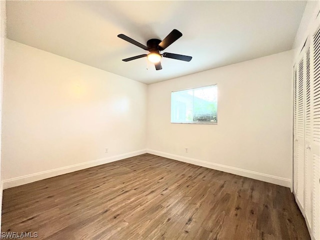 unfurnished bedroom featuring ceiling fan, dark hardwood / wood-style flooring, and a closet