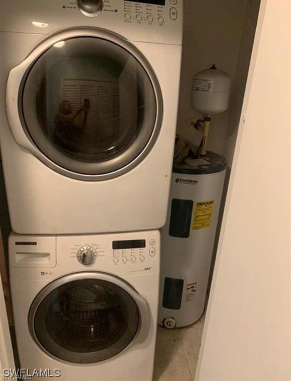 washroom featuring electric water heater, tile patterned flooring, and stacked washer and clothes dryer