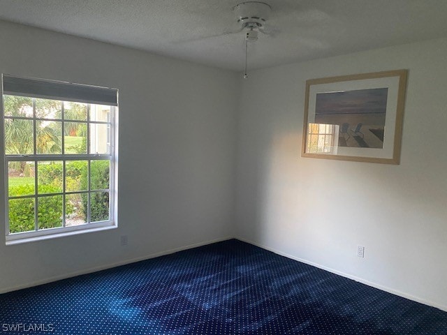 carpeted spare room with a textured ceiling and ceiling fan