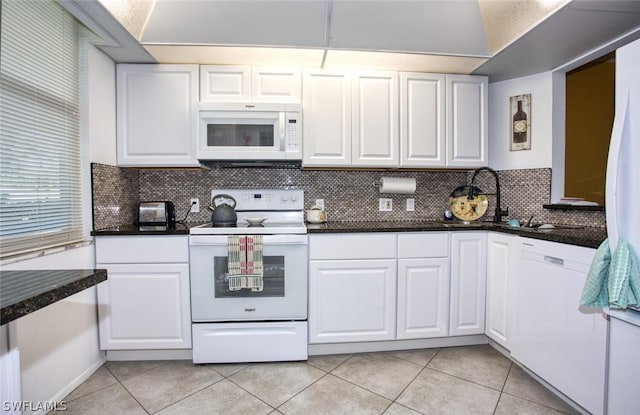 kitchen with decorative backsplash, light tile patterned floors, white appliances, and white cabinetry