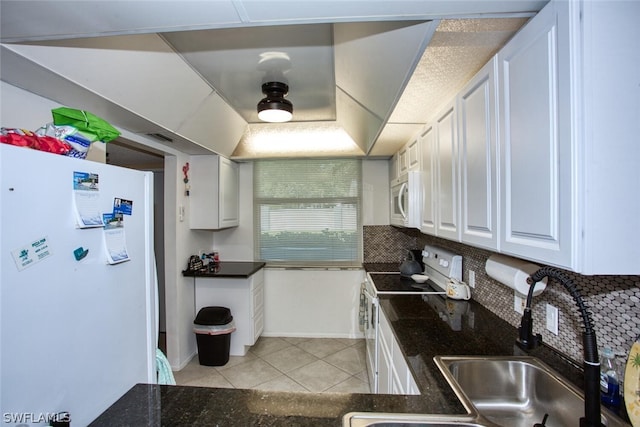 kitchen featuring white appliances, sink, decorative backsplash, light tile patterned flooring, and white cabinetry