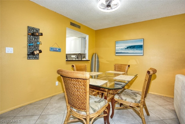 dining room with light tile patterned floors and a textured ceiling