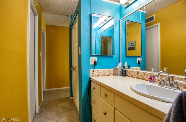 bathroom featuring tile patterned floors, vanity, and a textured ceiling