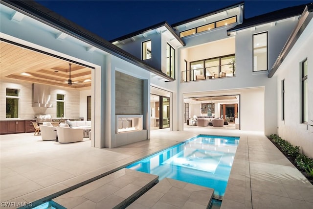 rear view of house with an outdoor living space, a patio, and exterior kitchen