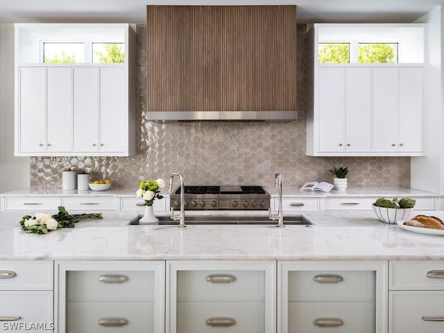 kitchen with tasteful backsplash, white cabinetry, and plenty of natural light