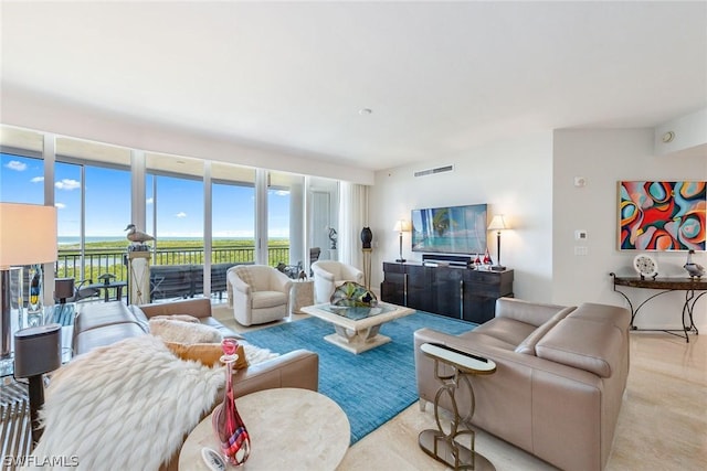 living room featuring a wall of windows and light carpet