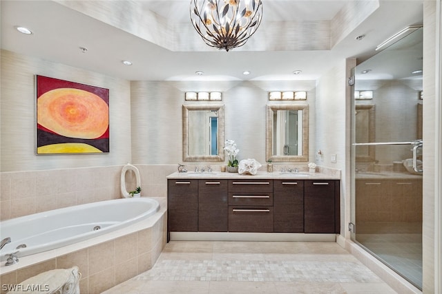 bathroom with tile patterned flooring, a notable chandelier, dual bowl vanity, shower with separate bathtub, and a raised ceiling