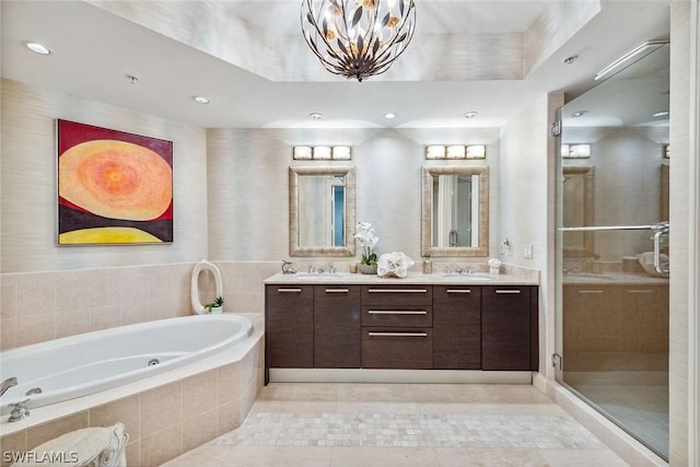 full bathroom featuring double vanity, a stall shower, tile patterned floors, a garden tub, and a sink