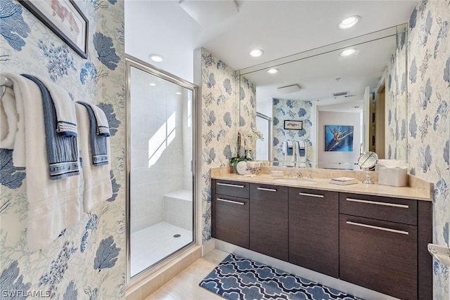 bathroom with tile patterned floors, a shower stall, vanity, and wallpapered walls