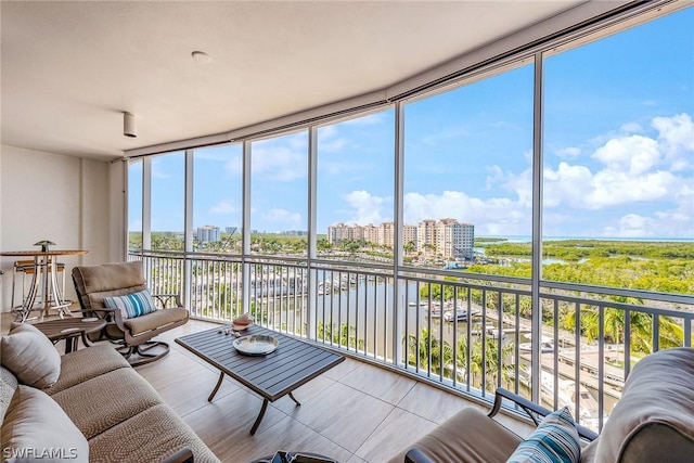 sunroom with a view of city and a water view