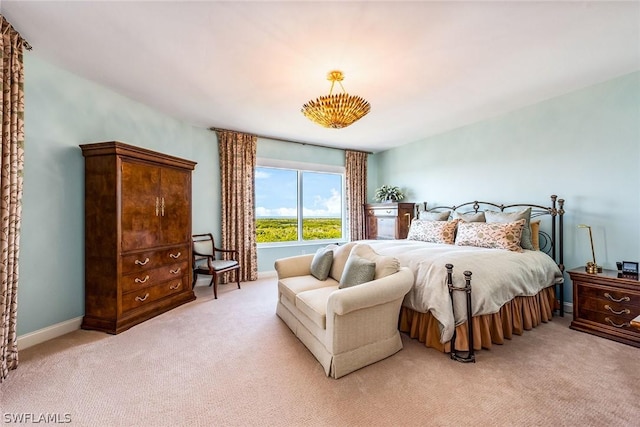 bedroom with baseboards and light colored carpet