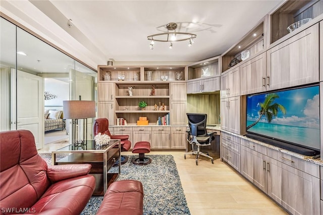 living room featuring light wood finished floors and built in study area