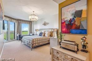 carpeted bedroom featuring a chandelier