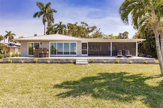 rear view of property featuring a lawn and a patio area