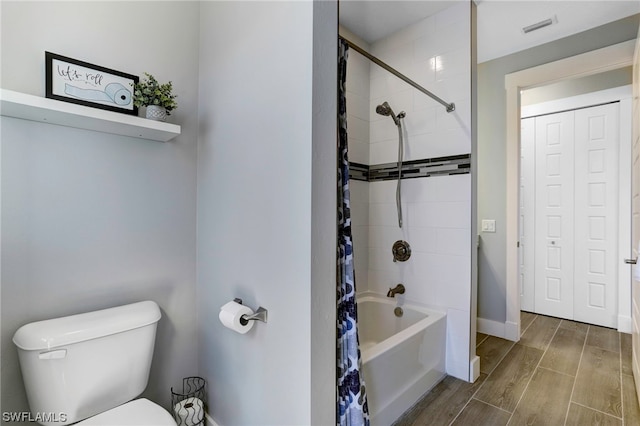 bathroom with shower / bath combination with curtain, toilet, and wood-type flooring