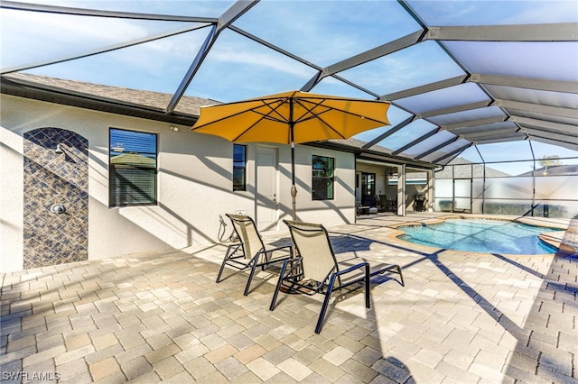 view of pool with a patio area and glass enclosure