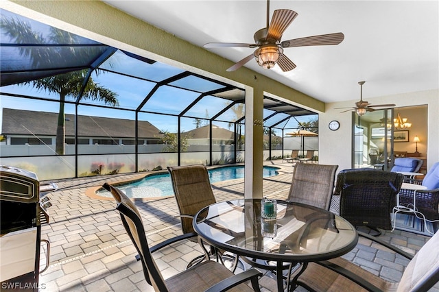 sunroom / solarium featuring ceiling fan with notable chandelier