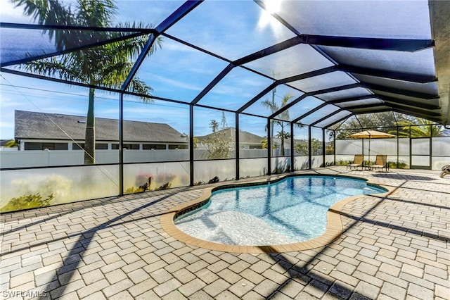 view of swimming pool with a patio area and a lanai