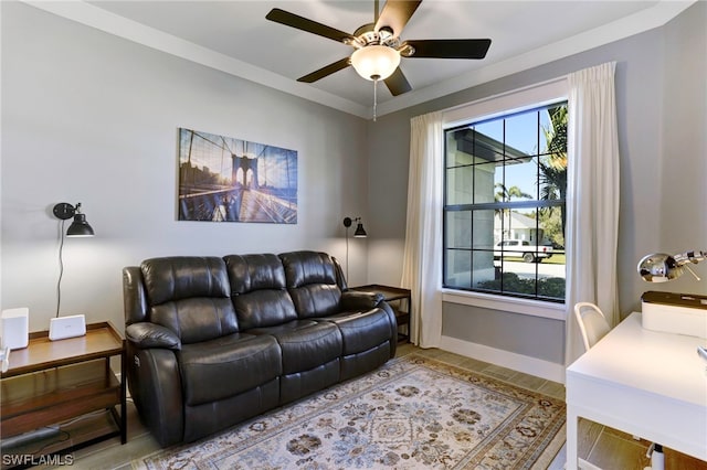 living room with ornamental molding and ceiling fan