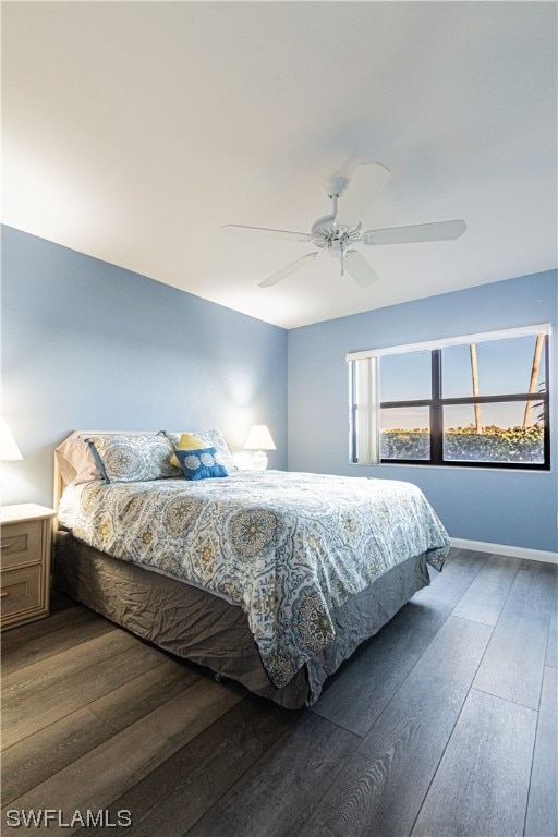 bedroom with dark hardwood / wood-style flooring and ceiling fan