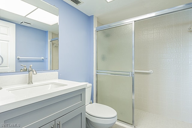 bathroom with an enclosed shower, toilet, and large vanity