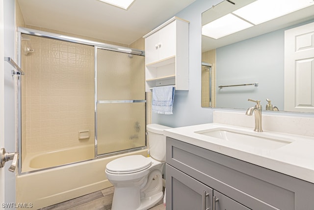 full bathroom featuring shower / bath combination with glass door, oversized vanity, and toilet