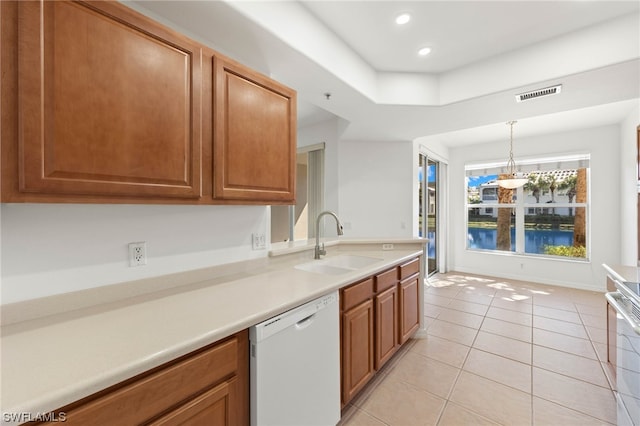 kitchen featuring light tile flooring, white dishwasher, hanging light fixtures, and sink