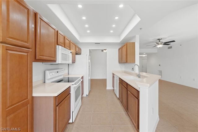 kitchen featuring ceiling fan, light tile floors, a raised ceiling, and white appliances