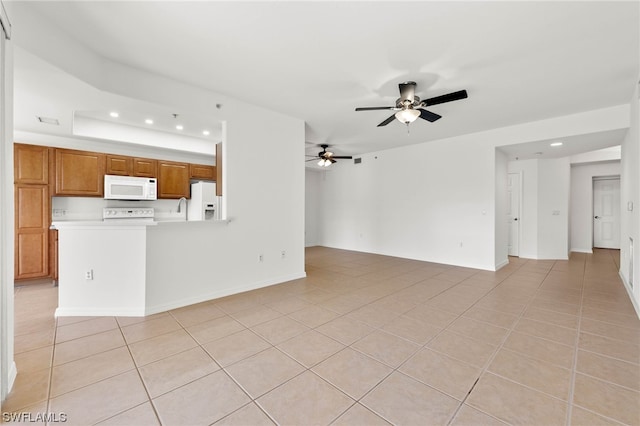 unfurnished living room featuring a raised ceiling, light tile flooring, and ceiling fan