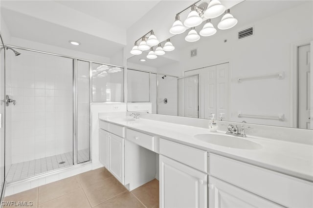 bathroom featuring walk in shower, oversized vanity, tile flooring, and dual sinks