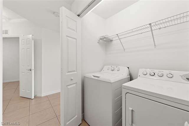 laundry area with light tile flooring and washer and clothes dryer