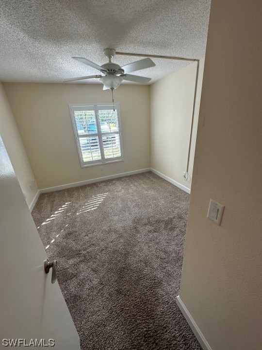 empty room featuring a textured ceiling, ceiling fan, and carpet floors