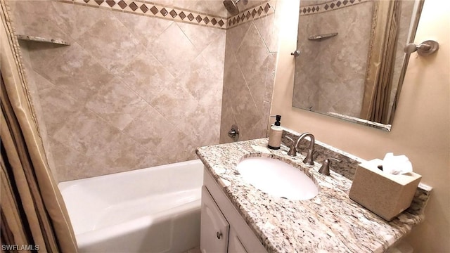 bathroom with tiled shower / bath combo and vanity