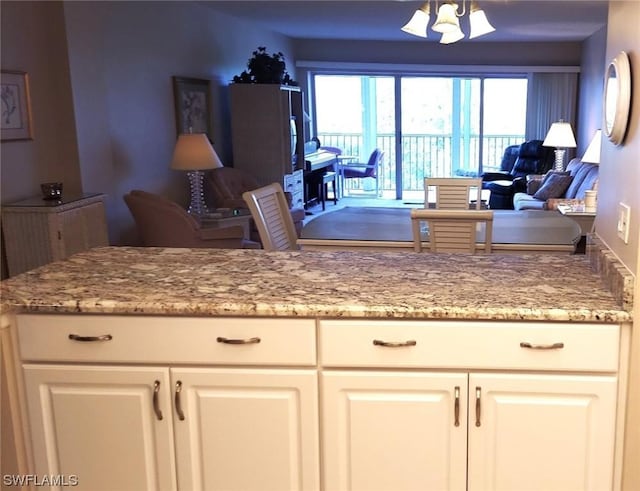 kitchen with white cabinetry and light stone countertops