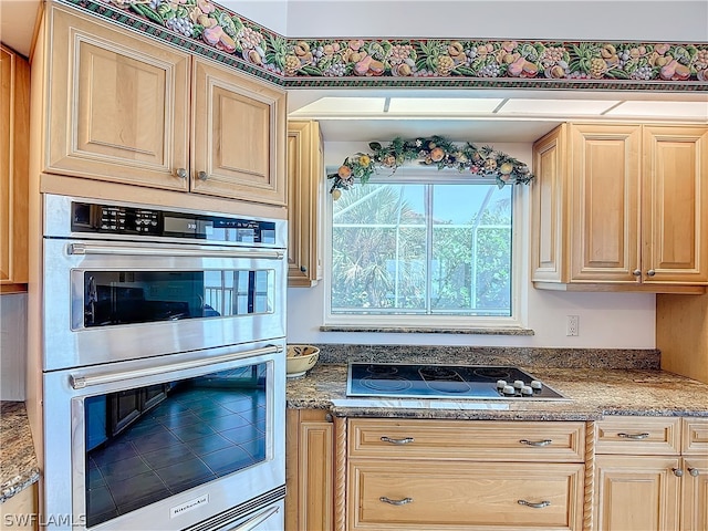 kitchen featuring light brown cabinetry, black electric cooktop, and double oven