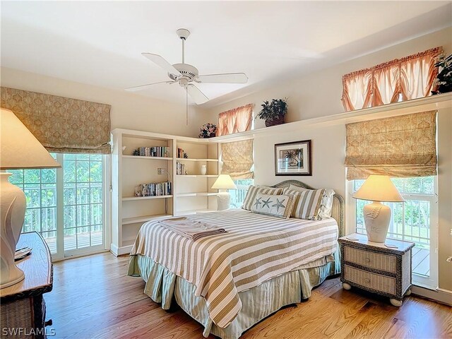 bedroom featuring access to exterior, multiple windows, ceiling fan, and hardwood / wood-style floors