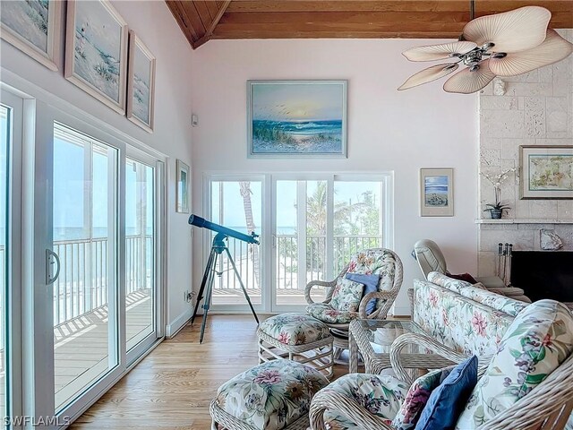 living room with ceiling fan, vaulted ceiling, light wood-type flooring, and wooden ceiling