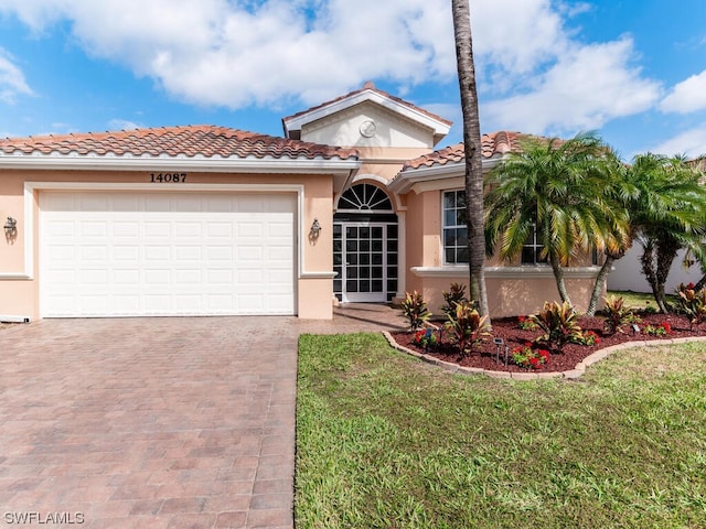 mediterranean / spanish house featuring a front lawn and a garage