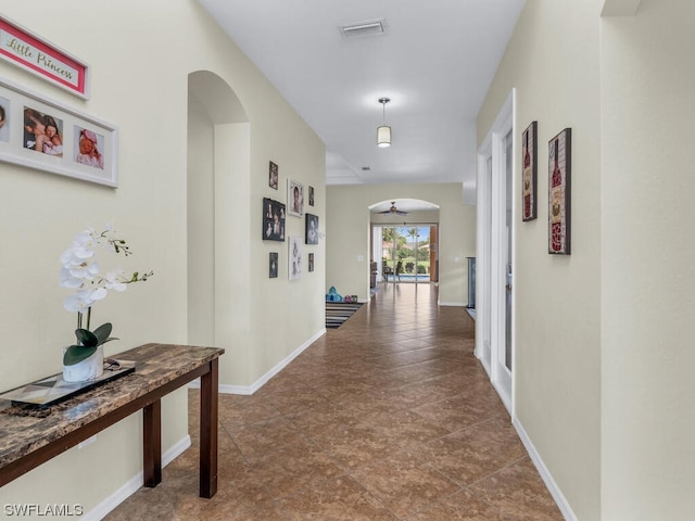 corridor featuring dark tile floors